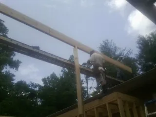 Carpenter setting a ridge beam over a new addition frame — Ice Dam Removal by Roofing Brothers in Cranbury