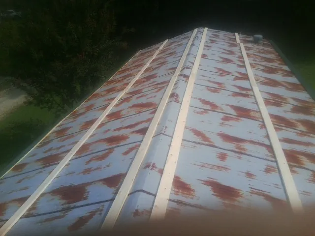 Rusted metal roof panels with new wood purlins before replacement — Storm Damage Roof Repair in Cranbury by Roofing Brothers