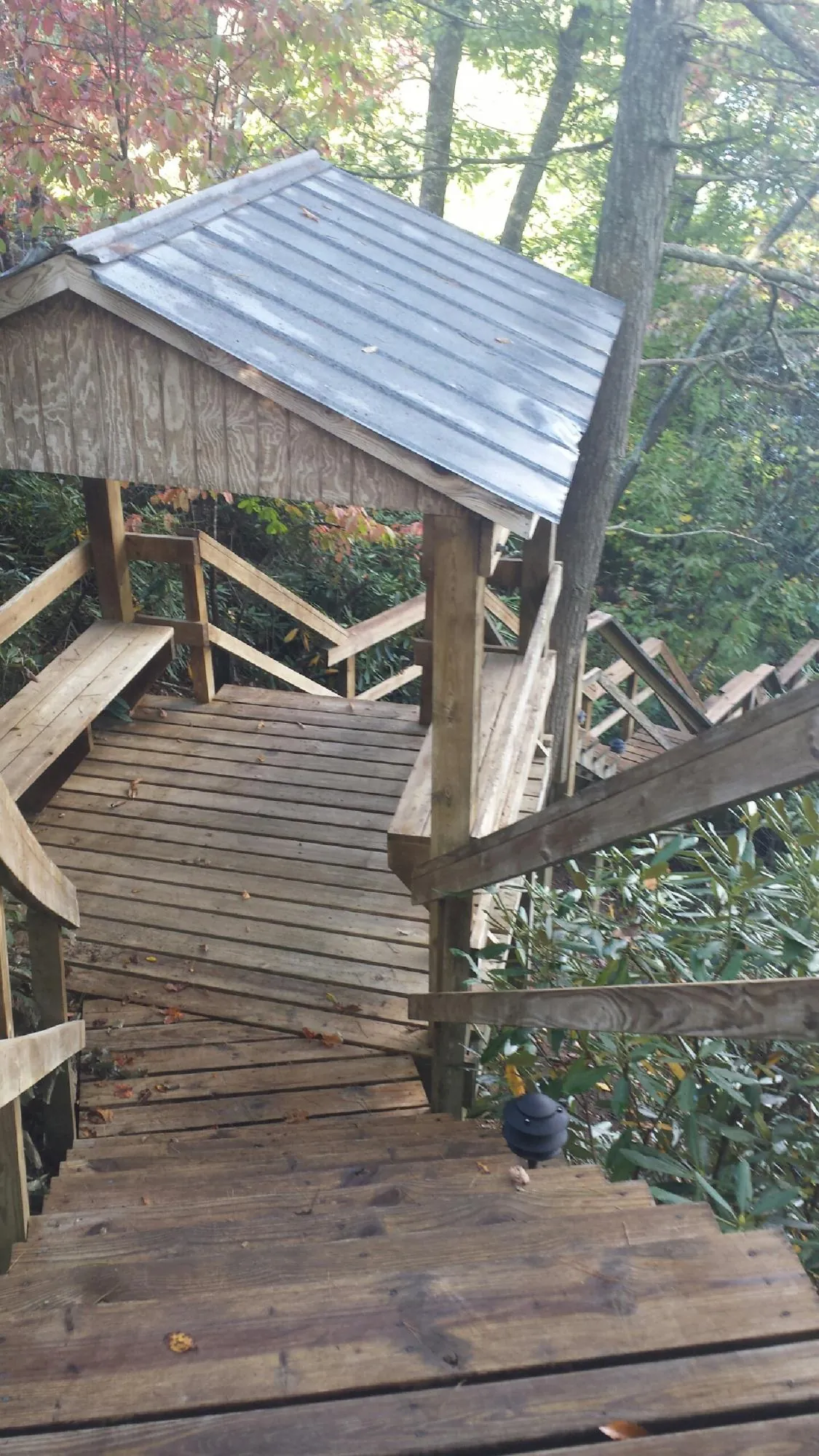 Metal roofed shelter over wooden steps on a wooded walkway — Skylight Repair & Installation work by our crew in Cranbury