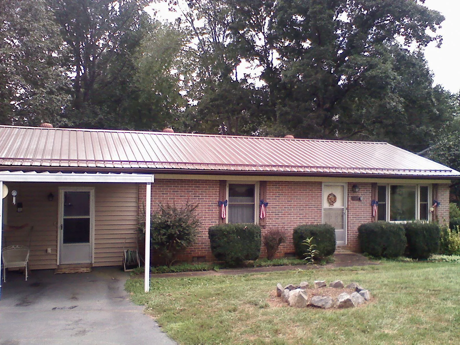 Bronze metal roof and carport on a brick ranch home — Roof Repair work by our crew in Cranbury